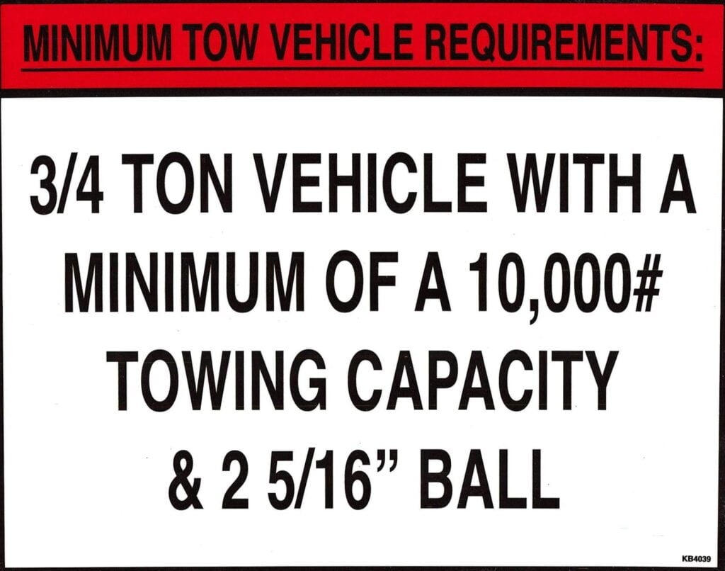 Minimum tow vehicle requirements sign showing 3/4 ton truck and 10,000-pound towing capacity recommendations for RV towing safety.