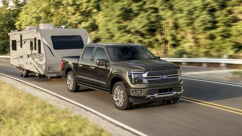 Ford F-150 towing a travel trailer on a forest highway demonstrating proper travel trailer towing setup and towing capacity basics.