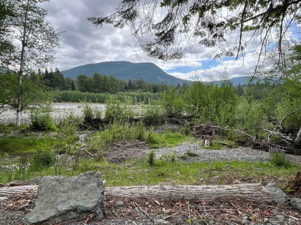 Scenic river valley surrounded by lush evergreen trees and mountains near Mount Rainier RV camping destinations in Washington State.