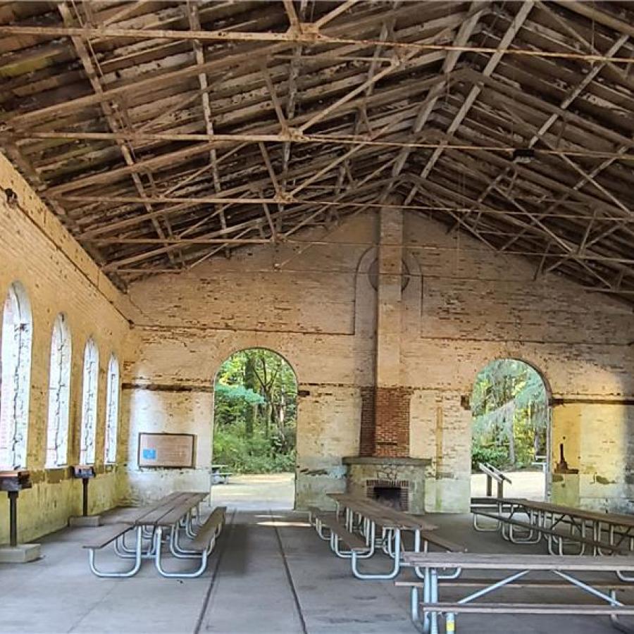 Historic Torpedo Warehouse interior at Manchester State Park with rustic beams and picnic seating, showcasing unique attractions near top Puget Sound RV campgrounds for Summer 2026 adventures.