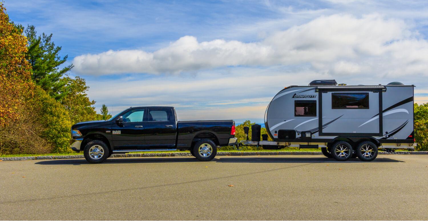 Half-ton pickup truck towing a lightweight travel trailer, demonstrating proper truck and trailer towing capacity matching for beginner RV owners.