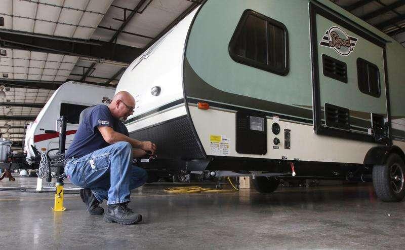 Technician performing a spring RV inspection on a travel trailer before summer camping season in the Pacific Northwest.