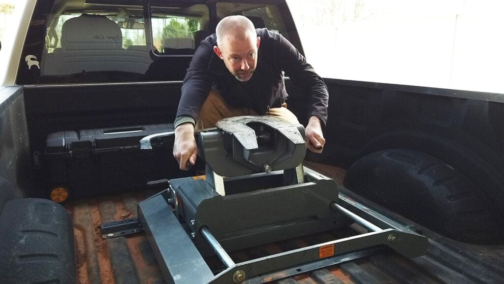 Inspecting and maintaining a fifth wheel hitch during spring RV maintenance before PNW summer camping season.