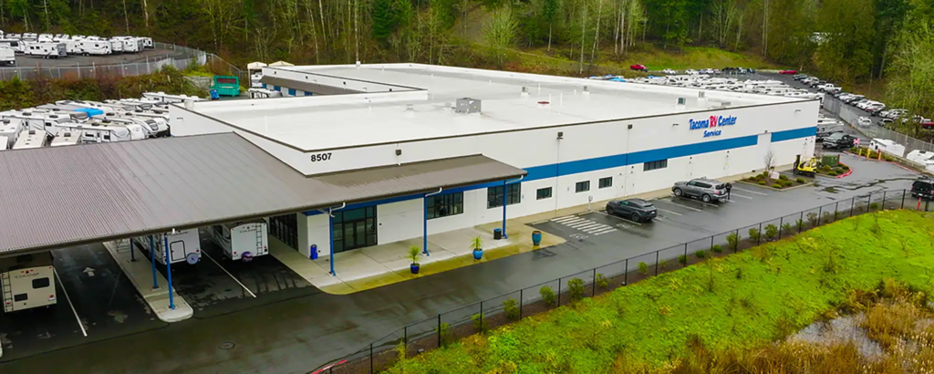 Aerial view of Tacoma RV Center Service Department in Washington featuring a large RV service facility, covered RV drop-off area, and multiple RVs ready for spring maintenance and repairs.