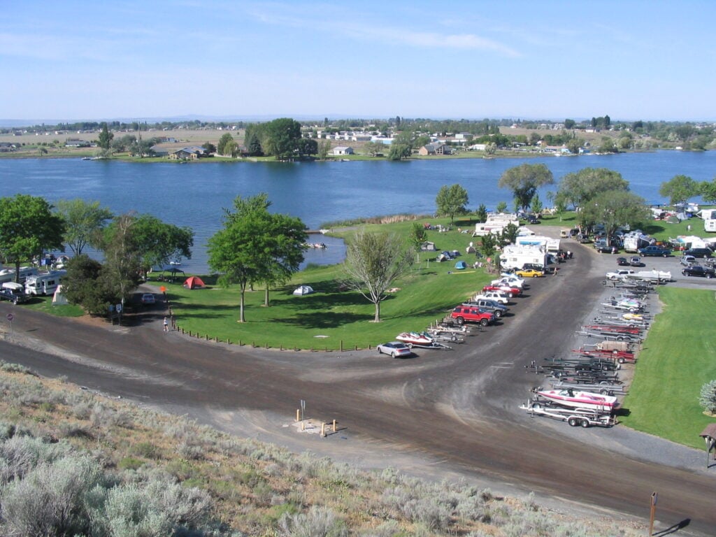 Aerial view of RV campground and boat launch area at Moses Lake in Washington State with RV sites, trailers, boats, and waterfront camping.